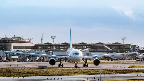 Avion taxi sur la piste de l'aéroport Paris-Orly sous un ciel nuageux.