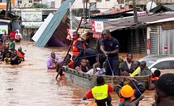Des habitants évacuent une rue inondée à Lomé à bord d'une barque artisanale après de fortes pluies.