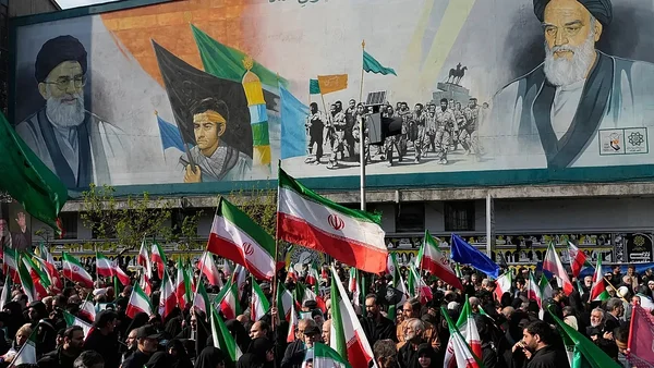 Manifestation de soutien au cessez-le-feu avec des drapeaux iraniens et une fresque des ayatollahs Khomeini et Khamenei.