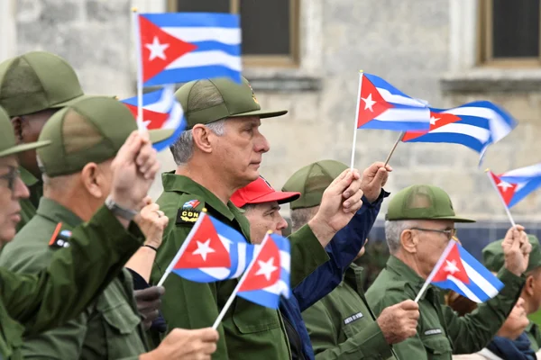 Des militaires cubains brandissant des drapeaux lors d'une parade patriotique.