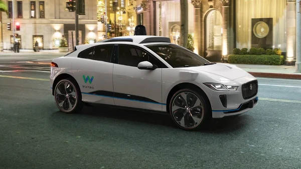 Robotaxi Waymo en circulation nocturne en milieu urbain.