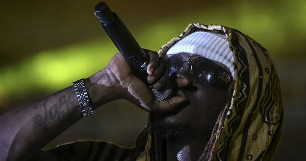 Snoop Dogg en concert, micro à la main, sous les projecteurs.