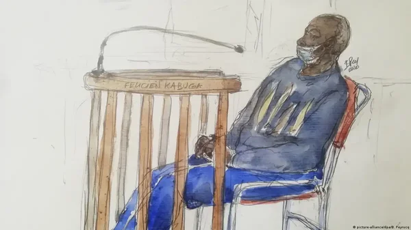 Croquis d'audience représentant Félicien Kabuga, masqué, assis à la barre des accusés.