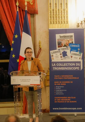 Aurore Bergé, ministre déléguée, s'adressant à l'audience lors d'un discours devant les drapeaux européen et français.