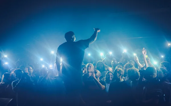 Ambiance électrique à La Place : un artiste hip-hop et son public les téléphones en l'air.