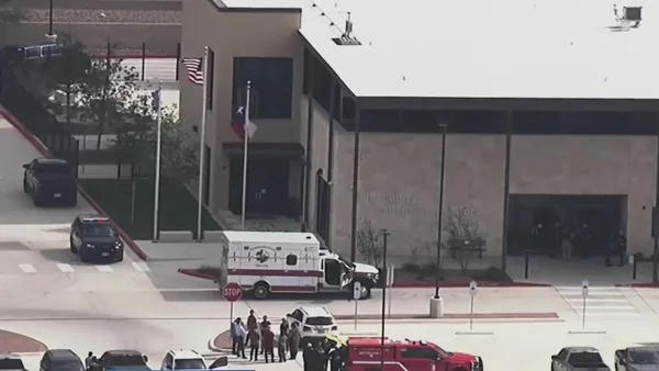 Ambulance et véhicules d'urgence devant le lycée après la fusillade.