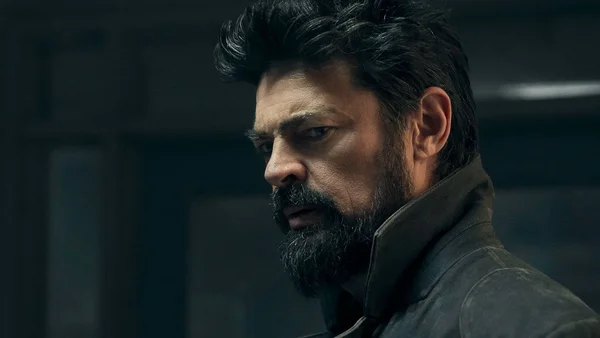 Portrait d'un homme barbu dans une atmosphère sombre.