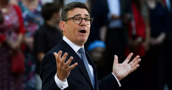 Andy Burnham s'exprimant avec gestes lors d'un événement.