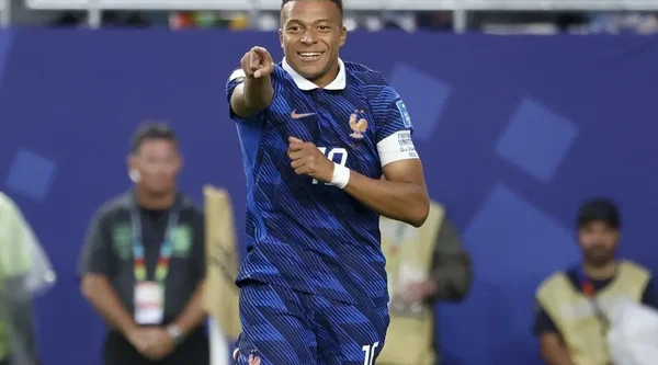Un joueur français souriant court sur le terrain.