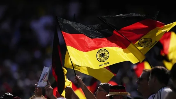 Supporters allemands agitant des drapeaux lors d'un événement sportif.