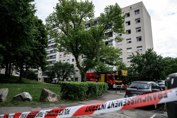 Ruban de police et camion de pompiers devant l'immeuble touché par l'incendie criminel à Décines-Charpieu.