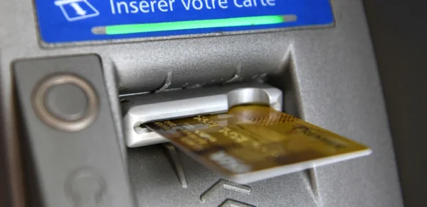Insertion d'une carte bancaire dans un distributeur automatique de billets.