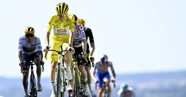 Le peloton du Tour de France, emmené par le maillot jaune, en pleine action sous un ciel éclatant.