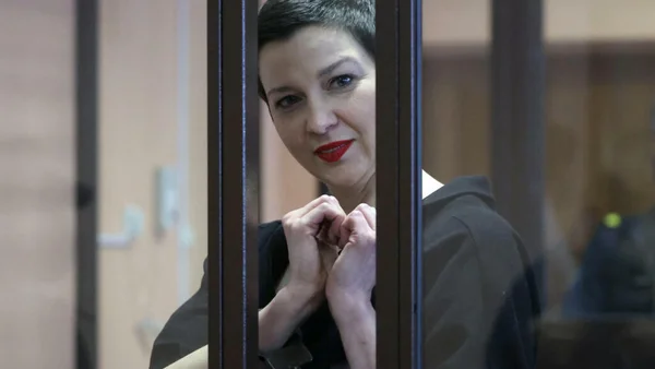 Maria Kolesnikova dans un cadre judiciaire, vue à travers une vitre.