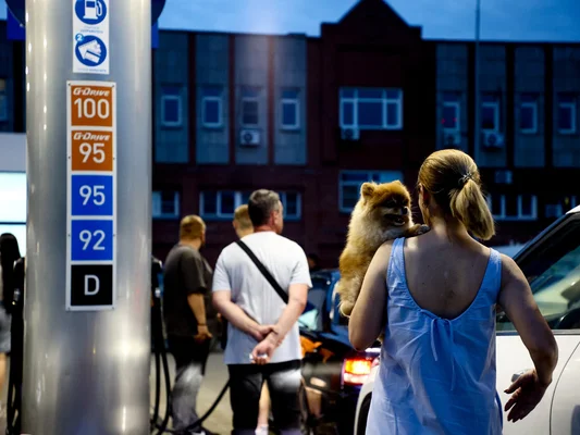 Cliente avec son chien dans une station-service, illustrant la ruée vers le carburant en Russie.