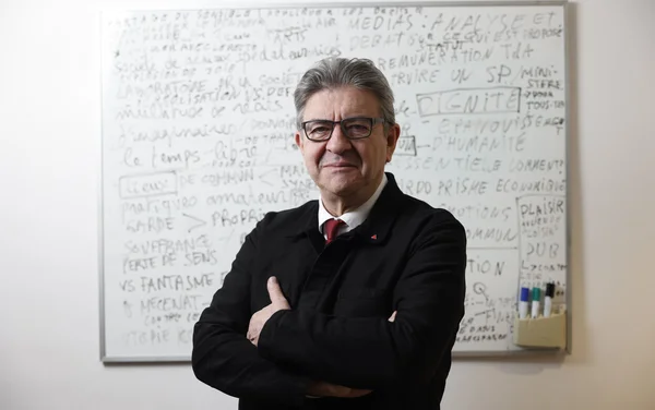 Jean-Luc Mélenchon, les bras croisés devant un tableau blanc, lors d'un entretien au Parisien en décembre 2021.