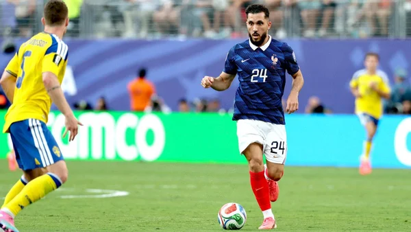 Rayan Cherki applaudissant sous le maillot de l'équipe de France après un match.