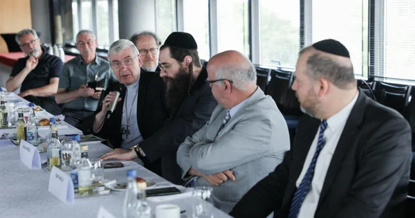 Dialogue interreligieux au sein du Conseil des cultes, avec un prêtre catholique et des représentants juifs.
