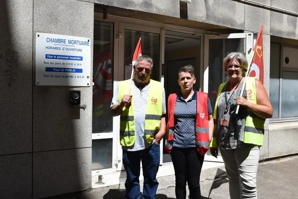Agents du service mortuaire du CHU de Nantes en grève, devant la chambre mortuaire, avec des drapeaux CGT.