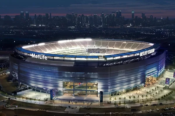 Le MetLife Stadium, lieu de la finale de la Coupe du monde 2026, vu de nuit avec New York en toile de fond.