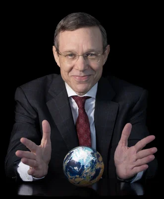 Portrait d'Avi Loeb, professeur d'astronomie à Harvard, tenant un globe terrestre.