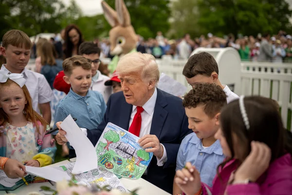 Donald Trump coloriant avec des enfants lors du roulage des œufs de Pâques à la Maison-Blanche, en avril 2025.