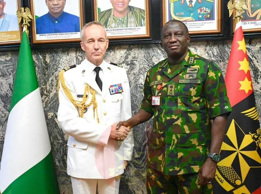 Officiers militaires nigérian et français échangeant une poignée de main lors d'une cérémonie de coopération.