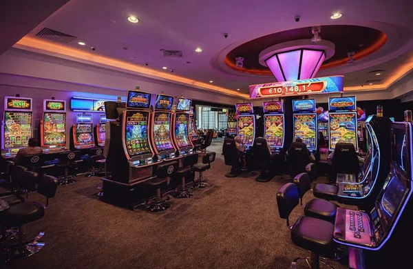 Intérieur du Casino JOA de Bagnoles de l'Orne, avec machines à sous et jackpot affiché.