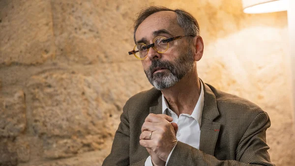 Robert Ménard, assis, mains jointes.
