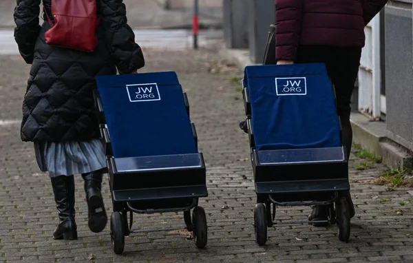 Témoins de Jéhovah avec des chariots de littérature portant le logo JW.ORG.
