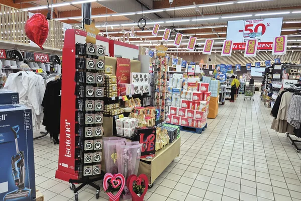 Magasin de grande distribution avec une promotion mise en avant par une pancarte suspendue, typique des publicités visées par l'interdiction.