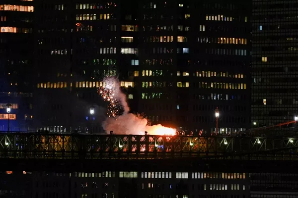 Feu et étincelles sur la passerelle piétonne du pont de Brooklyn pendant l'incendie du 4 juillet 2026.