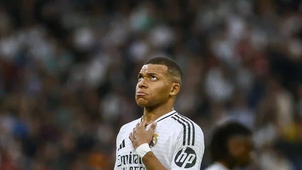 Kylian Mbappé, la main sur le cœur, avec le maillot du Real Madrid.