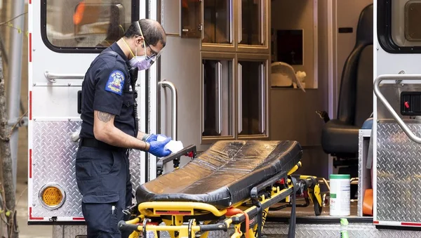 Un ambulancier nettoie un brancard après une intervention.