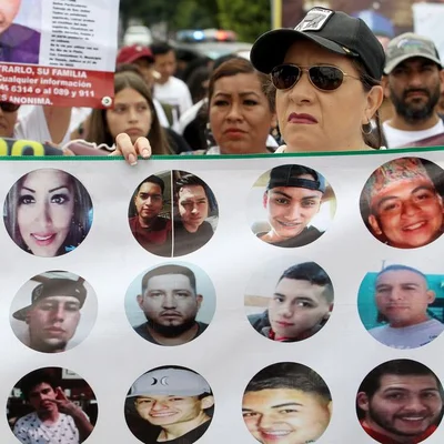 Une manifestante brandit des portraits de personnes disparues ou victimes de la violence des cartels au Mexique.