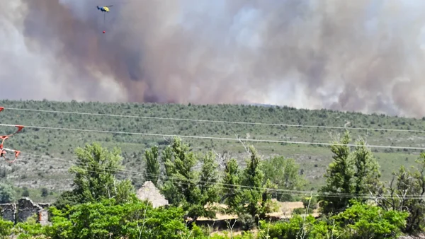 Hélicoptère larguant de l'eau sur l'incendie de La Mierla, dans le parc naturel de la Sierra Norte.