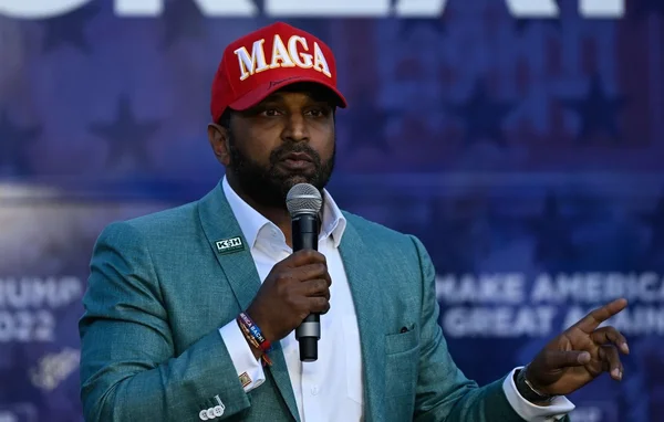 Kash Patel s'exprimant lors d'un rassemblement politique, arborant la célèbre casquette MAGA.