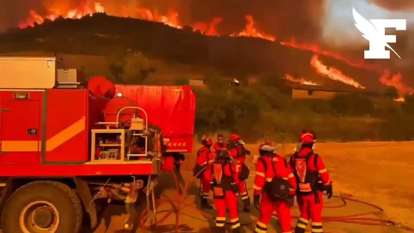 Pompiers espagnols observant un incendie de forêt dans le nord-est de l'Espagne.