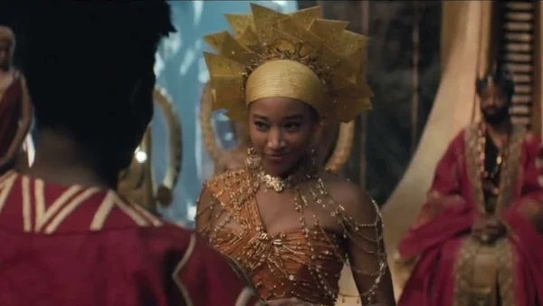 Scène du film de fantasy événement Le Royaume d'Orïsha, avec une actrice en costume traditionnel somptueux.