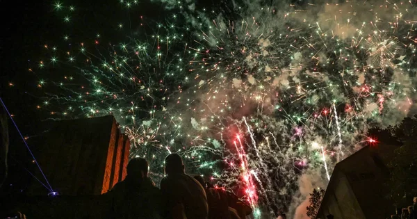 Feu d'artifice illuminant le ciel nocturne au-dessus de spectateurs en Gironde.