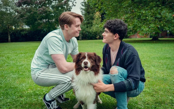 Nick et Charlie caressent un chien dans un parc, une scène touchante de la saison 3.
