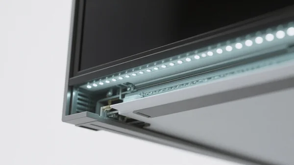 Gros plan sur la tranche d'un téléviseur fin, montrant la structure du rétroéclairage : une rangée de petites LED disposées sur le bord de l'écran. L'image doit communiquer la notion de technologie edge-lit de manière didactique et précise.