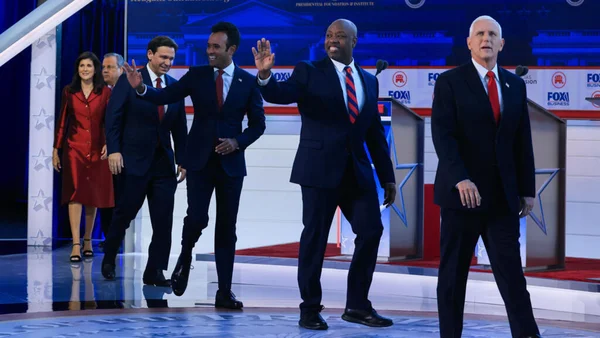 Candidats républicains se dirigeant vers le plateau d'un débat télévisé, avec Mike Pence et Nikki Haley au premier plan.