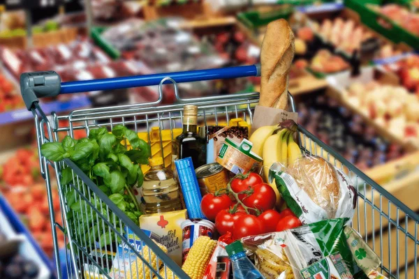 Un chariot de courses chargé de produits sains dans un supermarché.