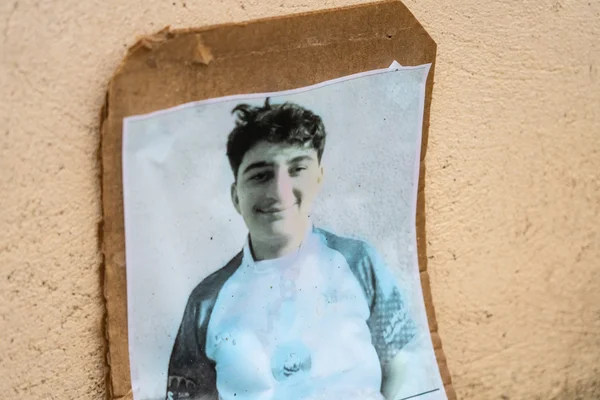 Hommage à Thomas : une photo du jeune homme scotchée sur un carton.
