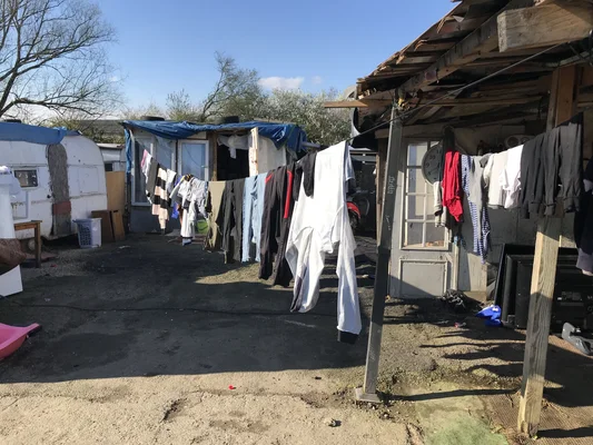 Une corde à linge dans un bidonville de Nantes, illustrant les conditions de vie précaires des habitants.