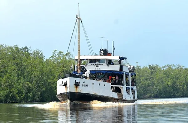 Le ferry MV Barima en navigation sur une rivière guyanaise, entouré de mangroves