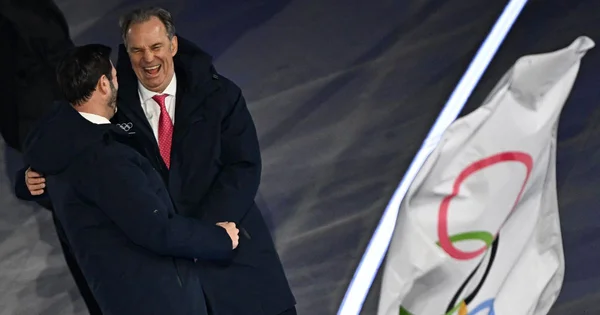 Renaud Muselier et un interlocuteur échangeant une accolade lors d'un événement olympique.