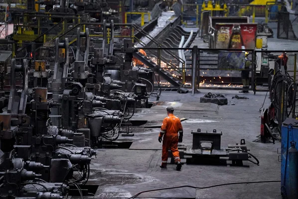 Ouvrier dans une aciérie britannique, symbole de l'industrie sidérurgique menacée.