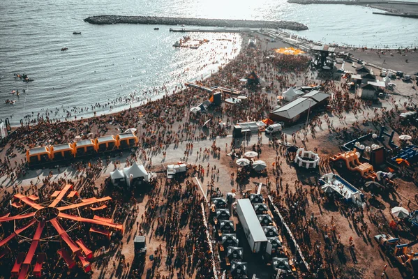 Vue aérienne du Delta Festival : plage bondée, grande roue et installations en bord de mer.